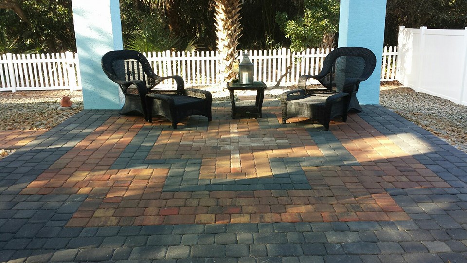 Finished paver patio with wicker outdoor furniture under a covered porch